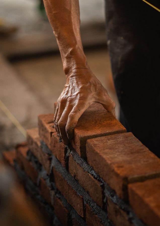Pose de briques par un maçon